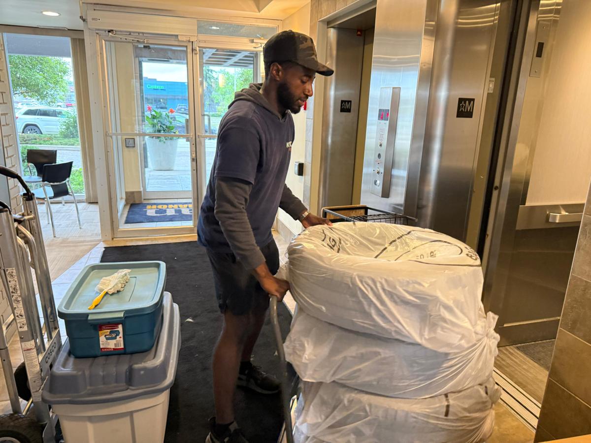 Movers navigating a stairwell with wrapped furniture