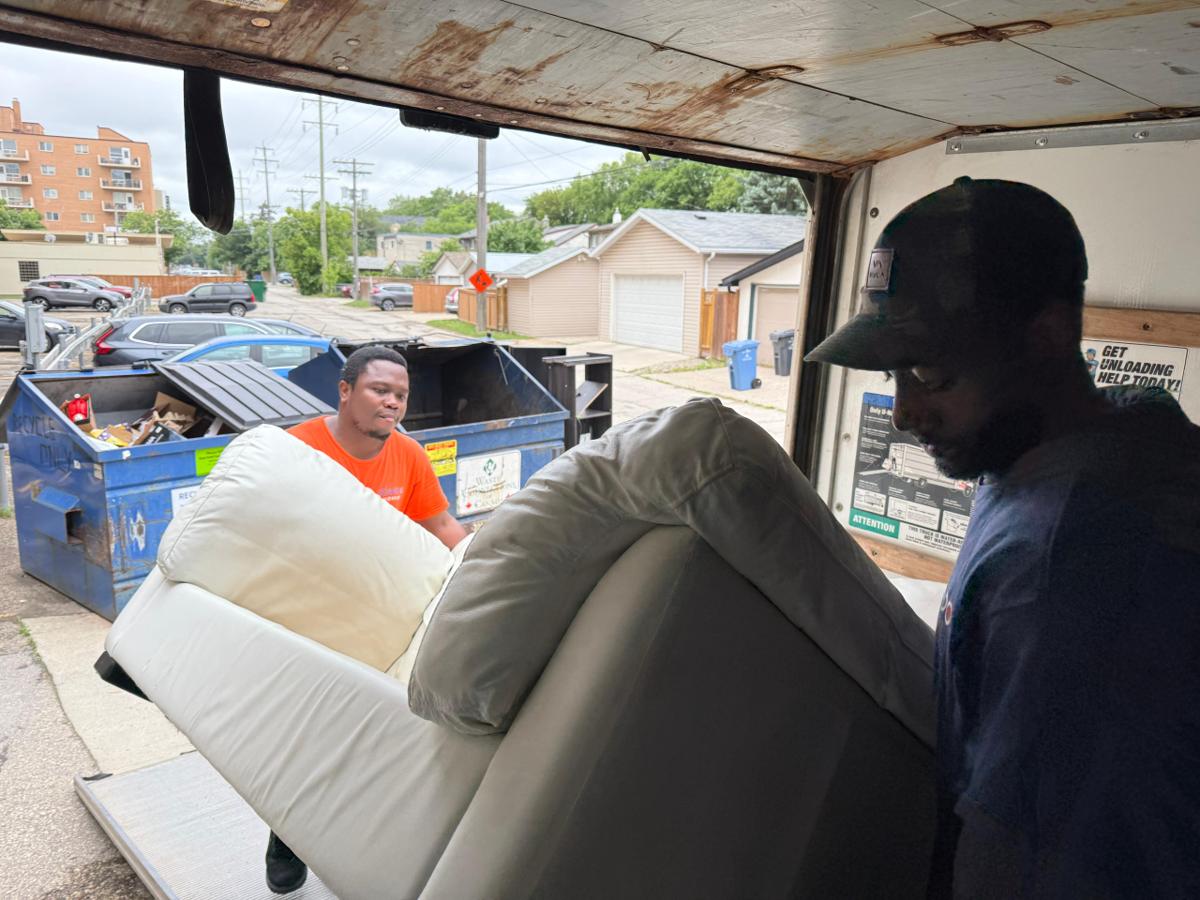 Two movers teamwork carrying furniture together